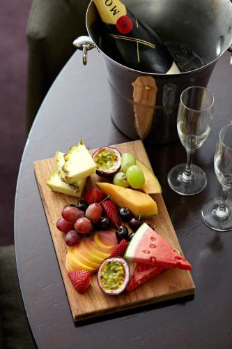 a cutting board with fruits and vegetables on a table at Establishment Hotel in Sydney