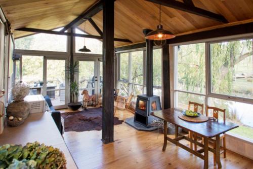 a living room with a table and a wood stove at Chum Creek Hut in Chum Creek