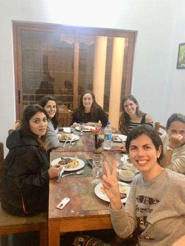 a group of people sitting around a wooden table at Spice Villa Thekkady in Thekkady