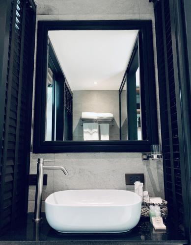 a bathroom with a large mirror and a tub at The Henry Hotel Manila in Manila