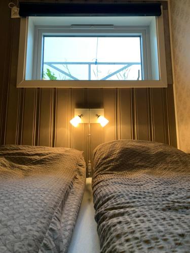 een slaapkamer met 2 bedden en een raam bij Cozy & private room in the middle of Lofoten in Leknes