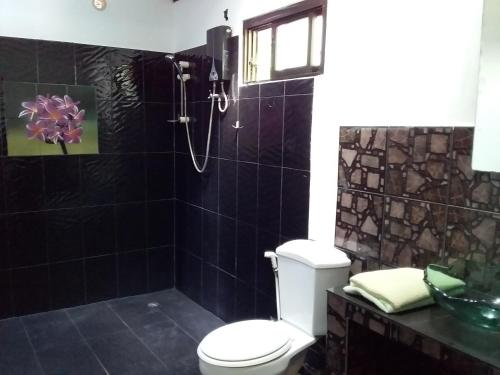 a bathroom with a shower with a toilet and a sink at Beautiful Flower Resort in Pak Meng