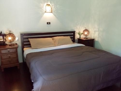 um quarto com uma cama com duas mesas de cabeceira e dois candeeiros em Beautiful Flower Resort em Pak Meng