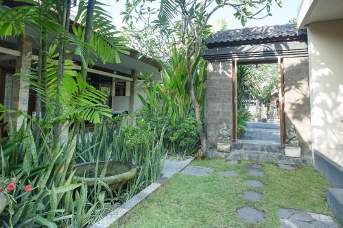 a garden entrance to a house with a large garden at Blanjong Homestay by ecommerceloka in Sanur