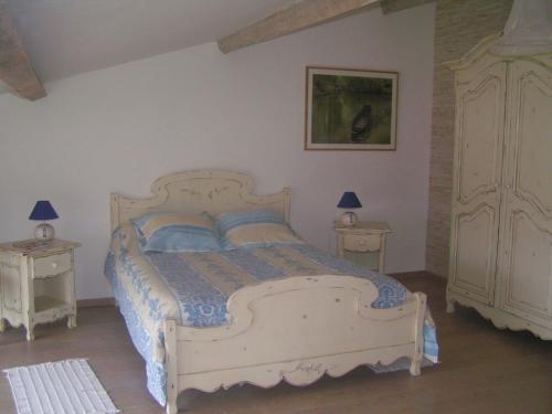 - une chambre avec un lit blanc et 2 tables de chevet dans l'établissement Au Bord de Sèvre, à Coulon