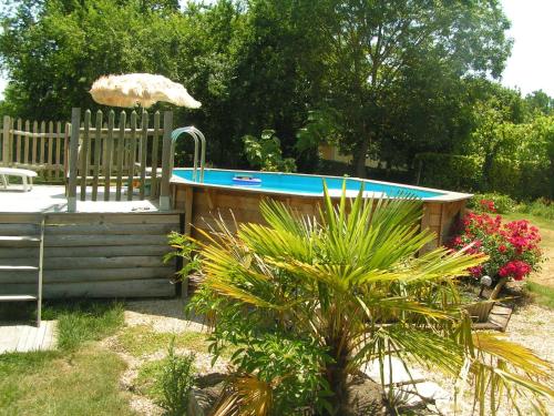 una piscina en un patio con una valla de madera en Au Bord de Sèvre, en Coulon
