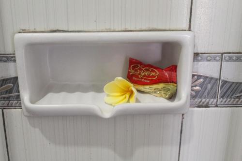 a box on the wall with a bag of chips and a flower at One Homestay and Warung in Munduk
