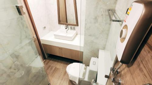 a bathroom with a sink and a toilet and a mirror at Pleasant Chiangmai in Chiang Mai
