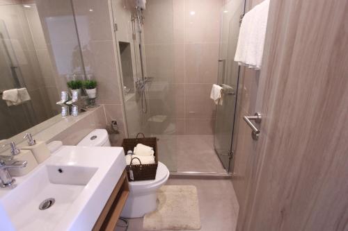 een badkamer met een douche, een toilet en een wastafel bij Serio Condo in Bangkok