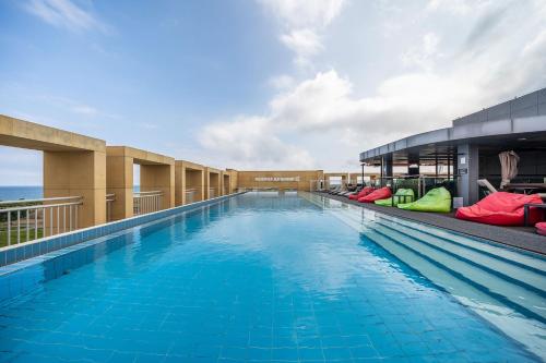 a large swimming pool on top of a building at Ktree Jeju Seongsan Hotel in Seogwipo
