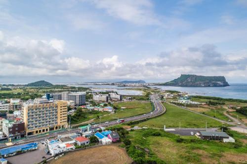 an aerial view of a city and the ocean at Golden Tulip Jeju Seongsan Hotel in Seogwipo