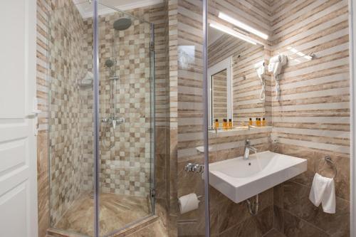 a bathroom with a sink and a glass shower at Marina White Sands Beach Hotel-All Inclusive in Obzor