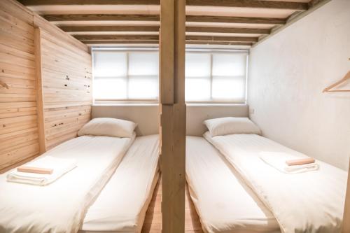 two beds in a room with two windows at Tiin Tinn Inn - Tiehua Xiutai in Taitung City