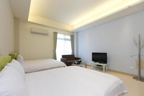 a hotel room with two beds and a television at 站前小松鼠電梯車位民宿-豪華雙人全新升級 in Hualien City