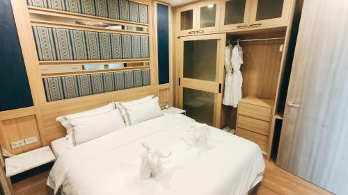 a bedroom with a white bed and a closet at Pleasant Chiangmai in Chiang Mai