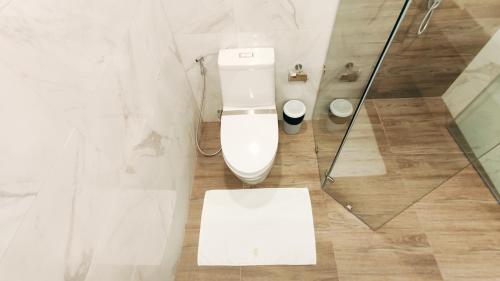 a bathroom with a toilet and a glass shower at Pleasant Chiangmai in Chiang Mai