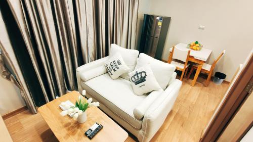a living room with a white couch and a table at Pleasant Chiangmai in Chiang Mai