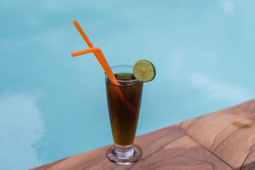 a drink with a lime on a wooden table at Five Rose Siem Reap Hostel in Siem Reap