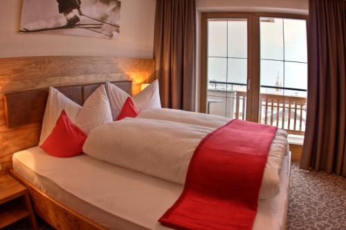 a bedroom with a bed with red and white pillows at AlpinApart Bacher in Serfaus