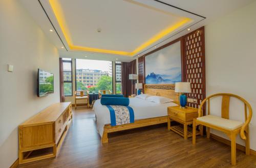 a bedroom with a bed and a desk and a chair at Riverside Inn Guilin Central in Guilin