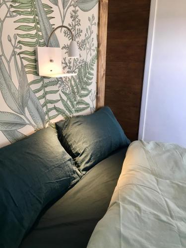 - un lit avec un oreiller et une lampe dans l'établissement COTTAGE A LA FONTAINE DU CHENE, à Lancôme