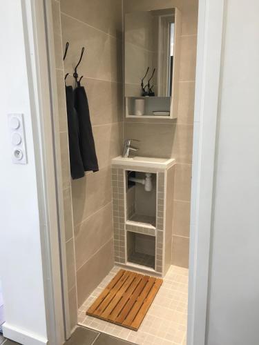 La salle de bains est pourvue d'une douche et d'une étagère en bois. dans l'établissement COTTAGE A LA FONTAINE DU CHENE, à Lancôme