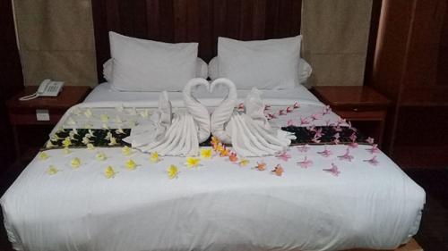 a bed with two swans made to look like hearts at Exotic Komodo Hotel in Labuan Bajo