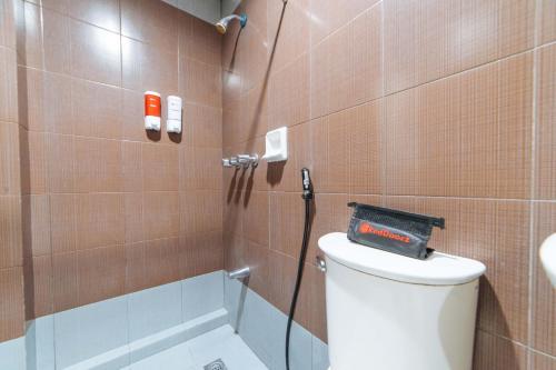 ein Bad mit einer Dusche, einem WC und einem Waschbecken in der Unterkunft RedDoorz near Olongapo Bus Terminal in Olongapo
