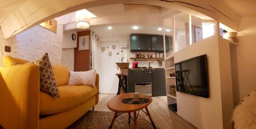 salon z żółtą kanapą i telewizorem w obiekcie Lovely Studio 1bdr City Center Studio La Tête dans Les Étoiles w Cannes