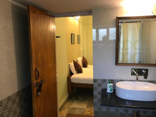 a bathroom with a sink and a bed with a mirror at Baaz Jungle Resort in Khawāsa