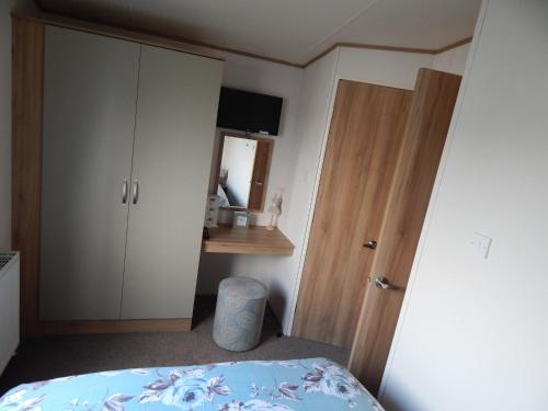 a bedroom with a bed and a closet and a door at Flamingo Land - Cedar Wood CW09 in Kirby Misperton