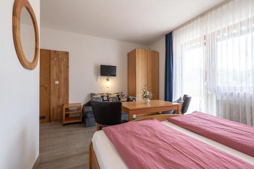 Habitación de hotel con cama, escritorio y mesa. en Gasthof Zur frohen Einkehr, en Reichardsroth