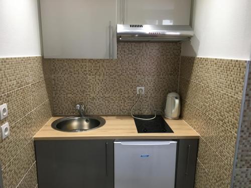 une petite cuisine avec un évier et un évier dans l'établissement Charmant Studio en plein centre ville, à Granville