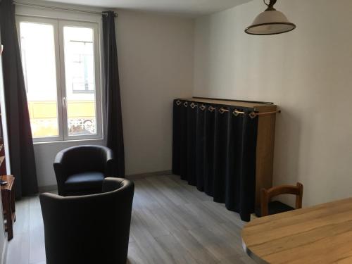 Cette chambre dispose de rideaux noirs, d'une table et de chaises. dans l'établissement Charmant Studio en plein centre ville, à Granville