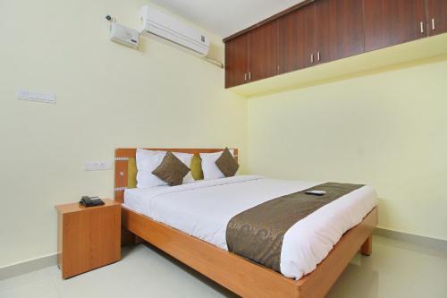 - une chambre avec un grand lit et une tête de lit en bois dans l'établissement Viswa Service Apartment, à Madurai