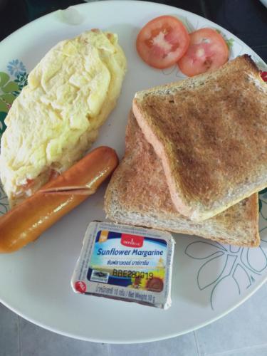 einen Teller mit Eiern, Toast und Tomaten in der Unterkunft Meechok organic home in Ao Nang Beach
