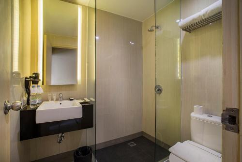 a bathroom with a sink and a glass shower at eL Hotel Jakarta in Jakarta