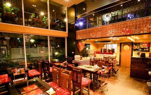ein Esszimmer mit Tischen und Stühlen in einem Restaurant in der Unterkunft Sabai Sabai@Sukhumvit Hotel in Bangkok