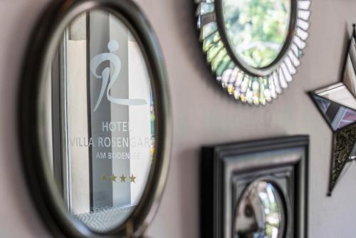 a group of mirrors on a wall with pictures at Hotel Garni Villa Rosengarten in Überlingen