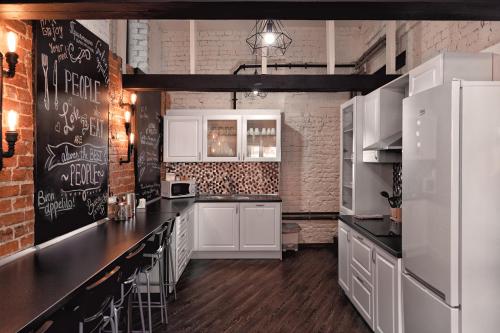 a kitchen with white appliances and a brick wall at Box Inn in Tver