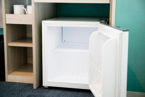 an empty white refrigerator in a room at Hotel Wing International Select Kumamoto in Kumamoto