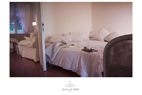 a bedroom with a bed with white sheets and flowers on it at Suites La Bella in Sopot