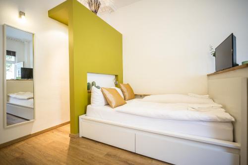 a bedroom with a large white bed with a mirror at Nena Apartments - Bergmannkiez ehm Traumbergflats in Berlin