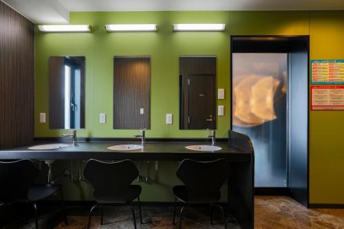 a row of sinks in a bathroom with green walls at Hotel Wing International Select Kumamoto in Kumamoto