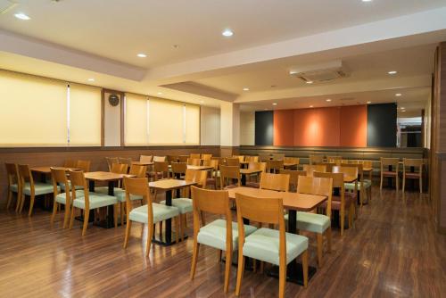 comedor con mesas y sillas de madera en Vessel Hotel Kurashiki, en Kurashiki