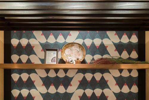 a shelf with a clock on top of it at Vessel Hotel Kurashiki in Kurashiki