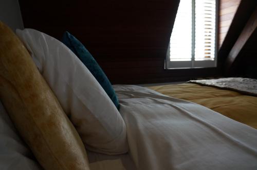 a bed with pillows in a room with a window at Charming Suites Jan Zonder Vrees in Antwerp