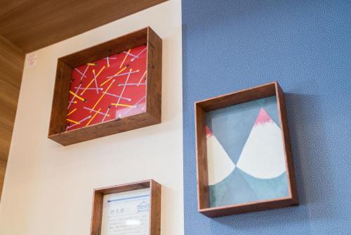 two pieces of art on the wall of a room at Vessel Hotel Kurashiki in Kurashiki