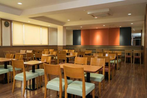 a restaurant with wooden tables and chairs at Vessel Hotel Kurashiki in Kurashiki