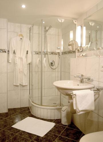 a white bathroom with a shower and a sink at Hotel Engel in Rheinmunster